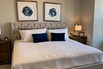 neatly made bed with art and bedside tables