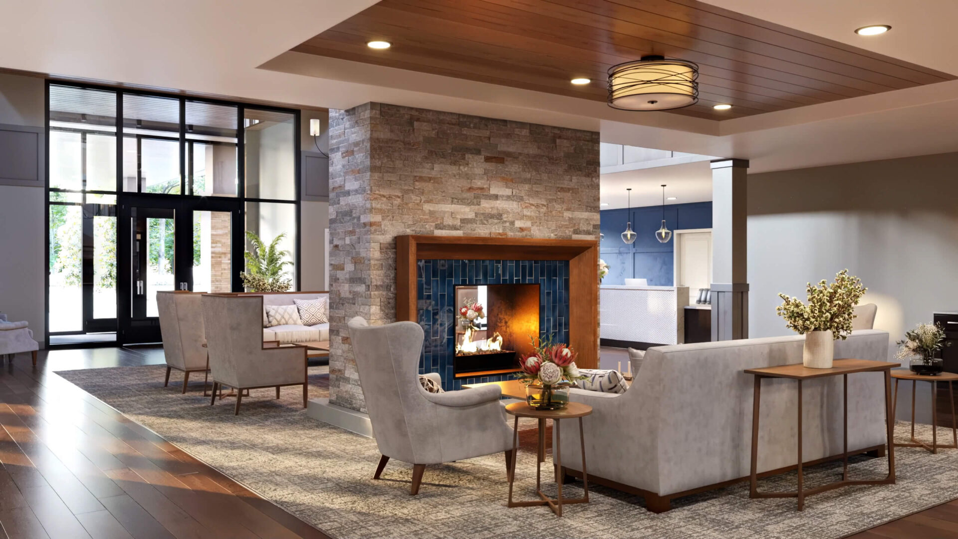 Spacious lobby with modern furniture and a central fireplace, featuring ample natural light.